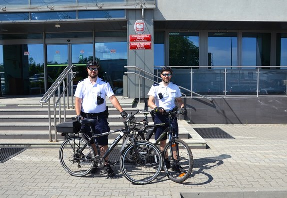 policyjny patrol rowerowy przed budynkiem komendy