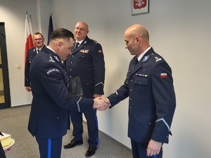 7. komendant powiatowy gratuluje zdającemu obowiązki podając dłoń, w tle zastępca komendanta wojewódzkiego