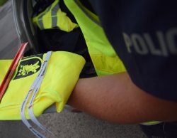 elementy odblaskowe trzymane w ręku przez policjanta