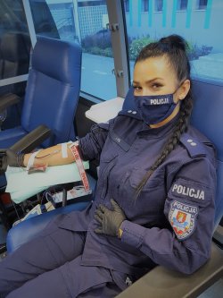 policjantka umundurowana podczas poboru krwi w krwiobusie
