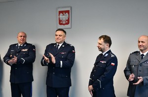 komendant wojewódzki i jego zastępca oraz zastępca komendanta KPP w krakowie biją brawa stojąceu obok nich przyszlemu emerytowi