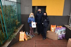 policjant i policjantka z przedstawicielka fundacji i przekazanymi darami