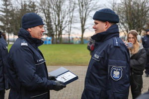 Komendant Augutyniak przekazuje kierownikowi posterunku symboliczny klucz