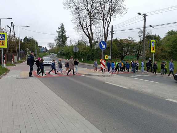 funkcjonariusze przeprowadzający dzieci przez przejście dla pieszych