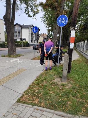 policjanci kontrolujący rowerzystę na ścieżce rowerowej, sprawdzają wyposarzenie roweru, przed nimi stojący rowerzysta