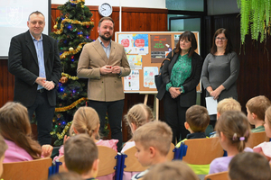 przedstawiciele starostwa i zarządu dróg powiatu krakowskiego stojący przed dziećmi