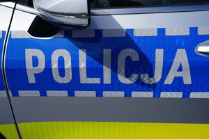 drzwi boczne oznakowanego radiowozu z napisem policja