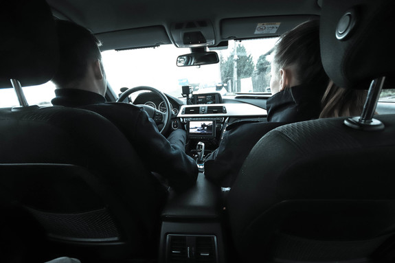 dwóch umundurowanych policjantów jadących radiowozem