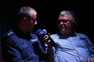 umundurowany policjant i dziennikarz radiowy z mikrofonem
