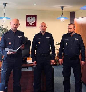 trzech umundurowanych policjantów stojących w gabinecie