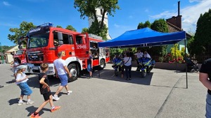 namiot pod którym stoją policyjne motory i umundurowani policjanci, obok wóz strażacki