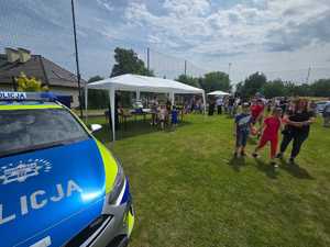policyjny radiowóz i namiot na boisku podczas pikniku