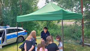 umundurowana policjantka przed nią grupka dzieci