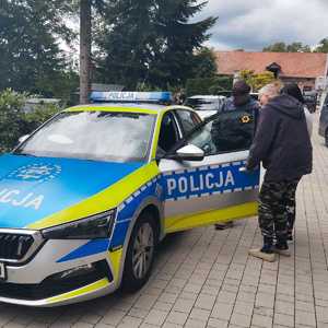 oznakowany radiowóz i oglądający ludzie