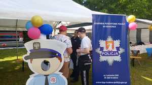 umundurowana policjantka na stoisku profilaktycznym z odwiedzającymi