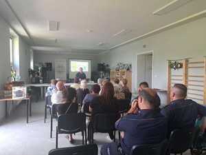 umundurowana policjantka podczas prelekcji, przed nią siedzą uczestnicy spotkania