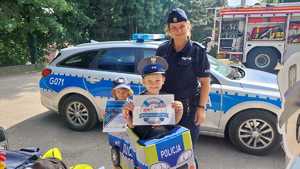 umundurowana policjantka z dziećmi przed radiowozem