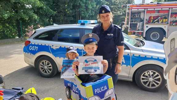 umundurowana policjantka z dziećmi przed radiowozem