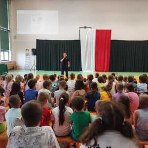 umundurowana policjantka, przed nią siedzą dzieci podczas prelekcji w szkole