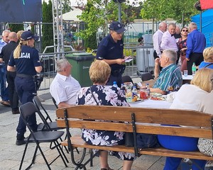 umundurowani policjanci podczas pikniku rozmawiają z seniorami