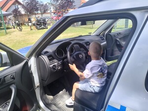 chłopiec siedzący za kierownicą radiowozu