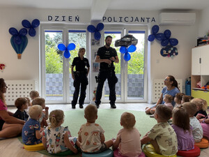 umundurowana policjantka i policjant stoją przed dziećmi w sali