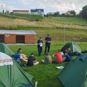 umundurowani policjanci na polu namiotowym przed młodzieżą
