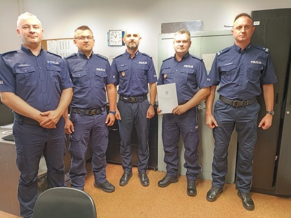 umundurowani policjanci stojący w pomieszczeniu komisariatu