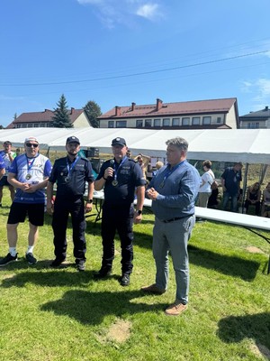 umundurowani policjanci obok nich dwóch mężczyzn podczas pikniku z okazji biegu