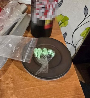 zielone tabletki leżące w woreczku na talerzu