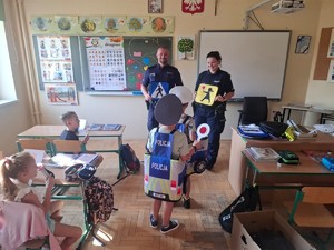 umundurowana policjantka i policjant w klasie przed nimi dzieci