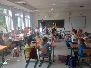 umunudorwani policjanci w klasie przed nimi siedzą dzieci w ławkach
