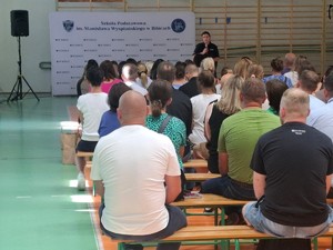 umunudorwna policjantka podczas wykładu na sali przed nią rodzice