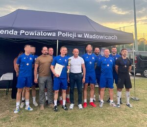 mężczyźni w strojach sportowych odbierają puchar