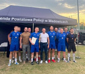 mężczyźni w strojach sportowych odbierają puchar
