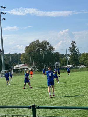 mężczyźni w strojach sportowych na boisku podczas rozgrzewki