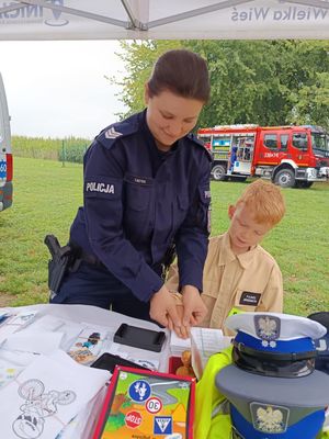 umundurowana policjantka z chłopcem przy stoisku policyjnym
