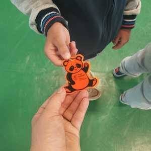 dłoń policjantki i ręka dziecka z elementem odblaskowym