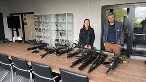 kobieta i mężczyzna stoją w sali przed nimi stół a na nim jednostki broni