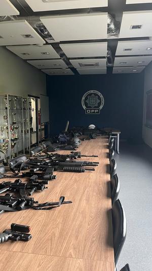 sala na OPP Kraków, na stołach leży broń oraz elementy wyposażenia policjantów z lewej strony gablota z pucharami
