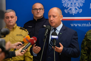 mężczyzna przed mikrofonem podczas konferencji prasowej