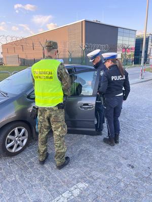 umundurowani funkcjonariusze policji i strażnik graniczny podczas kontroli pojazdu
