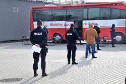 policjanci stojący w kolejce do krwiobusa