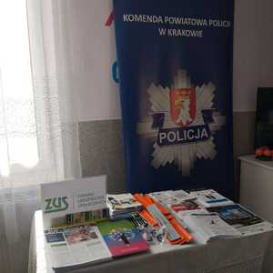 baner z logo komendy przed nim stół z ulotkami i broszurami