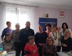umundurowany policjant na zdjęciu z seniorami