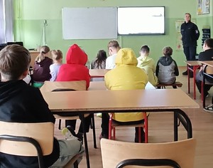 umundurowana policjantka, dzieci siedzące w sali