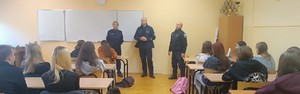 umundurowani policjanci, dzieci siedzące w szkolnych ławkach