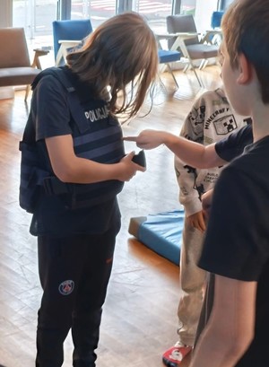 dziecko przymierza policyjną kamizelkę