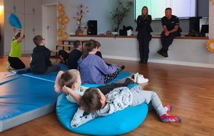 umundurowani policjanci przed nimi siedzące dzieci
