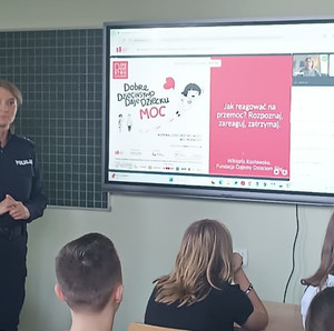 umundurowana policjantka za nią ekran z prezentacją